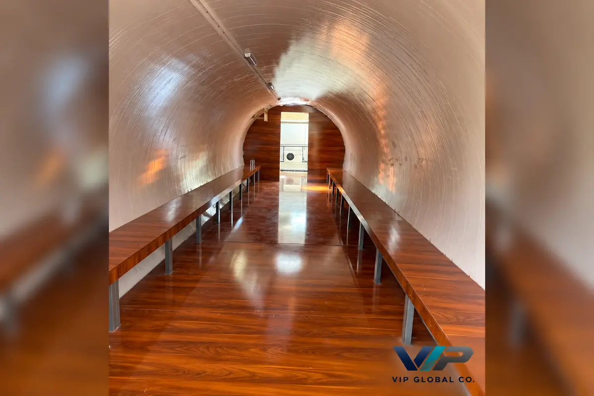 Curved hotel capsule interior with wood-effect flooring and side benches